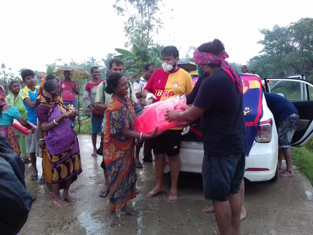 Saurav Moni and others handing relief supplies to villagers affected by Cyclone Amphan