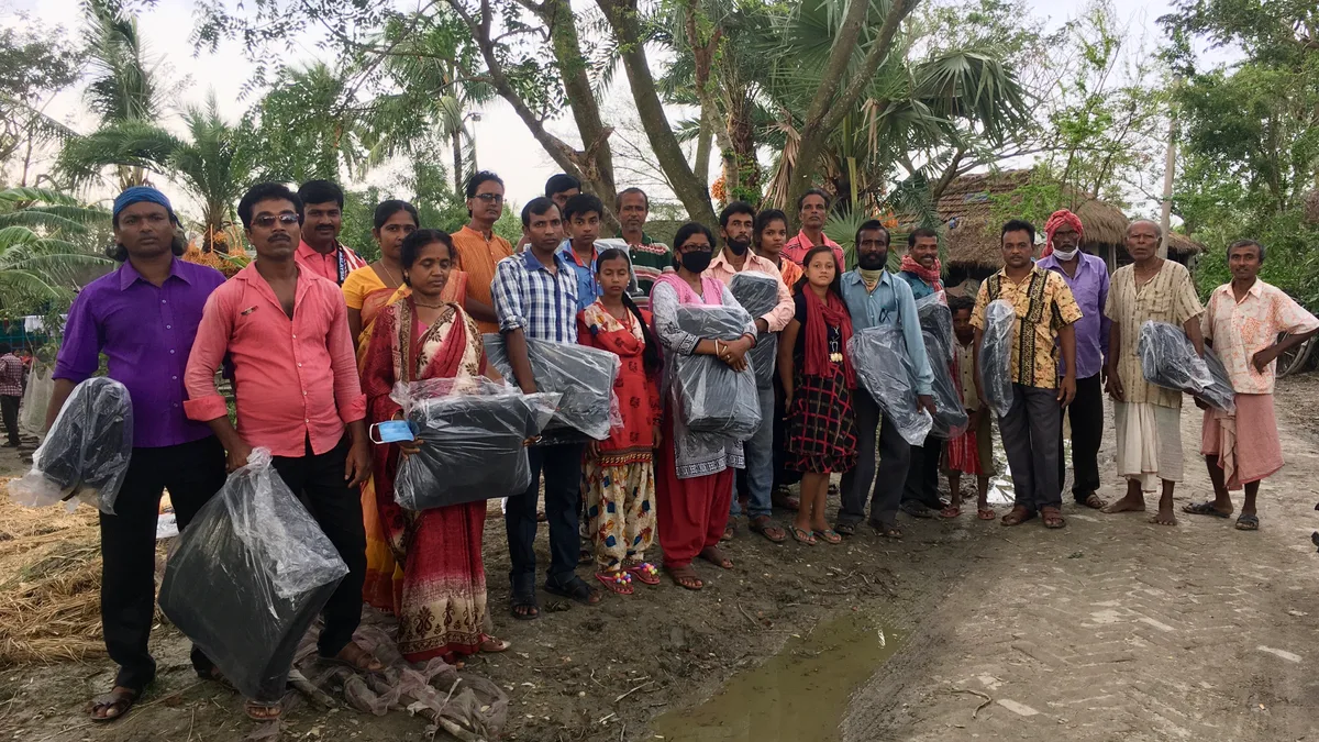 People gathered with relief materials after Cyclone Amphan
