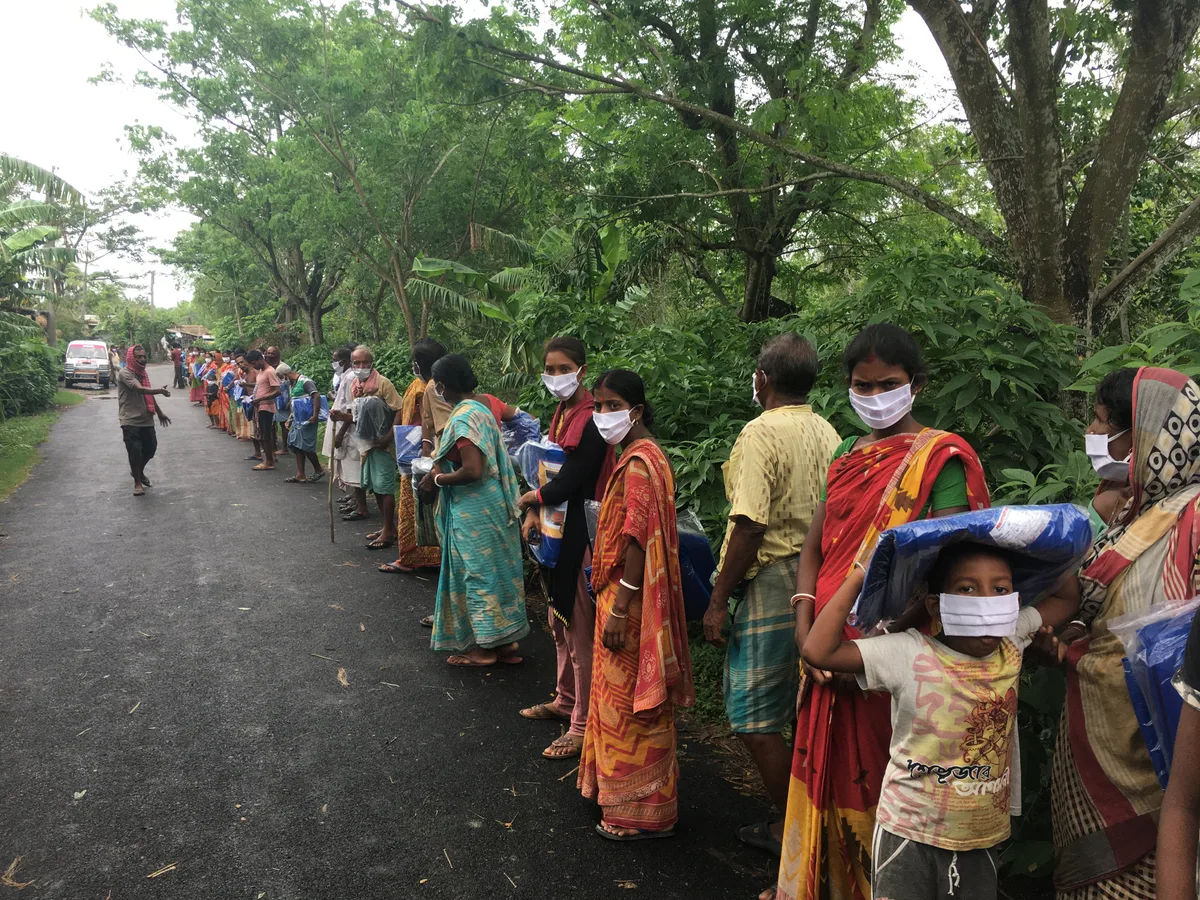 Villagers standing in line to receive food supplies after Cyclone Amphan