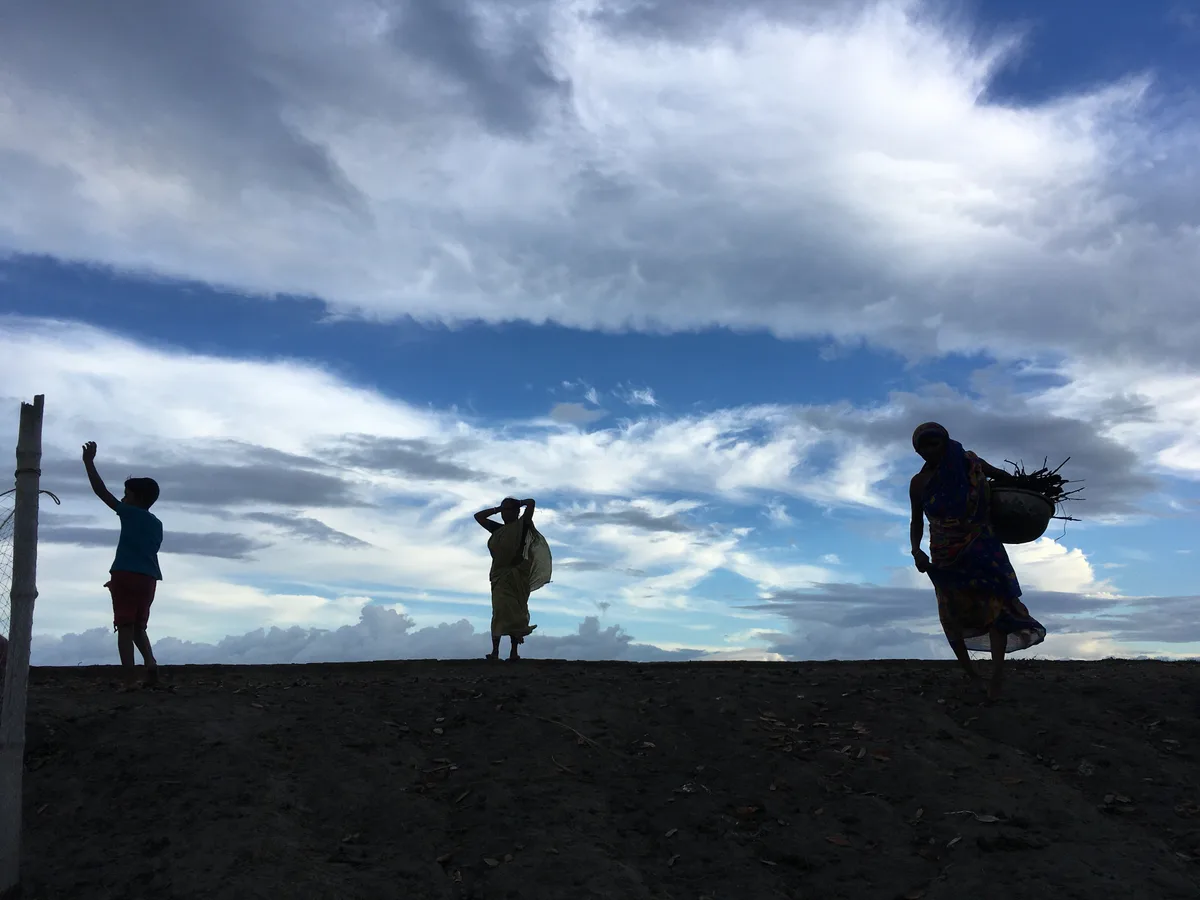 Silhouettes of people against a blue sky