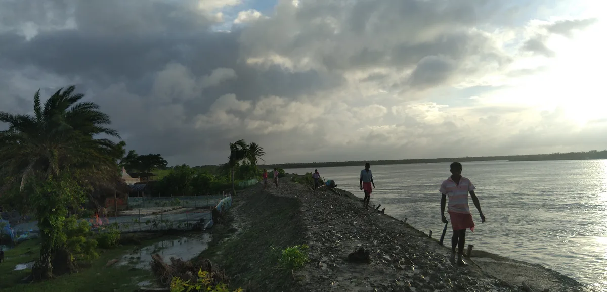 People walking beside a river at dawn