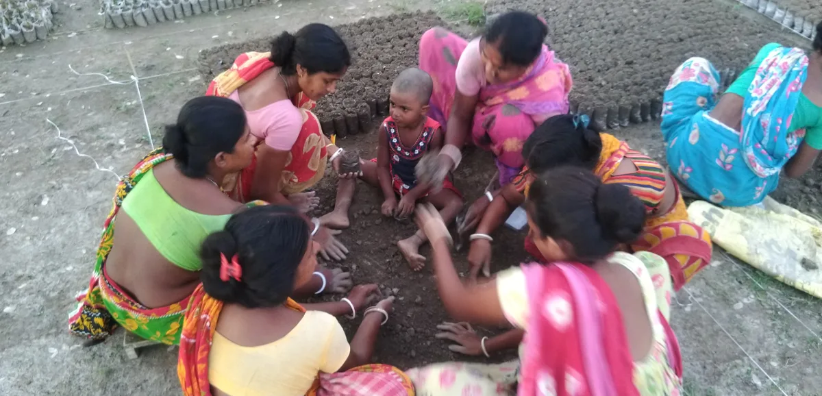 Women preparing soil for planting mangrove seeds